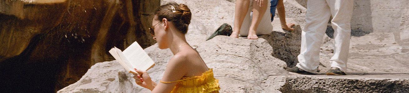 Seminario e mostra immagine di una turista che legge alla fontana di trevi